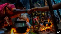 Tamil women welcome each other as they cook special food to celebrate the harvest festival of Pongal at Dharavi, one of the Asia&#39;s largest slums, in Mumbai, India.