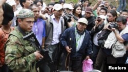 Un miembro de las FARC es rodeado por un grupo de índigenas y periodistas en uno de los accesos a Toribío, en la provincia del Cauca, donde los índigenas han exigido que se retiren los elementos armados de la guerrilla y el ejército.