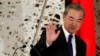 FILE - China's State Councilor and Foreign Minister Wang Yi waves as he leaves a news conference in Tokyo, Japan, Nov. 24, 2020. 