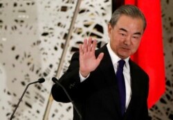 FILE - China's State Councilor and Foreign Minister Wang Yi waves as he leaves a news conference in Tokyo, Japan, Nov. 24, 2020.