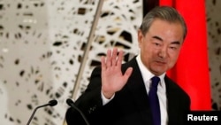 FILE - China's State Councilor and Foreign Minister Wang Yi waves as he leaves a news conference in Tokyo, Japan, Nov. 24, 2020. 