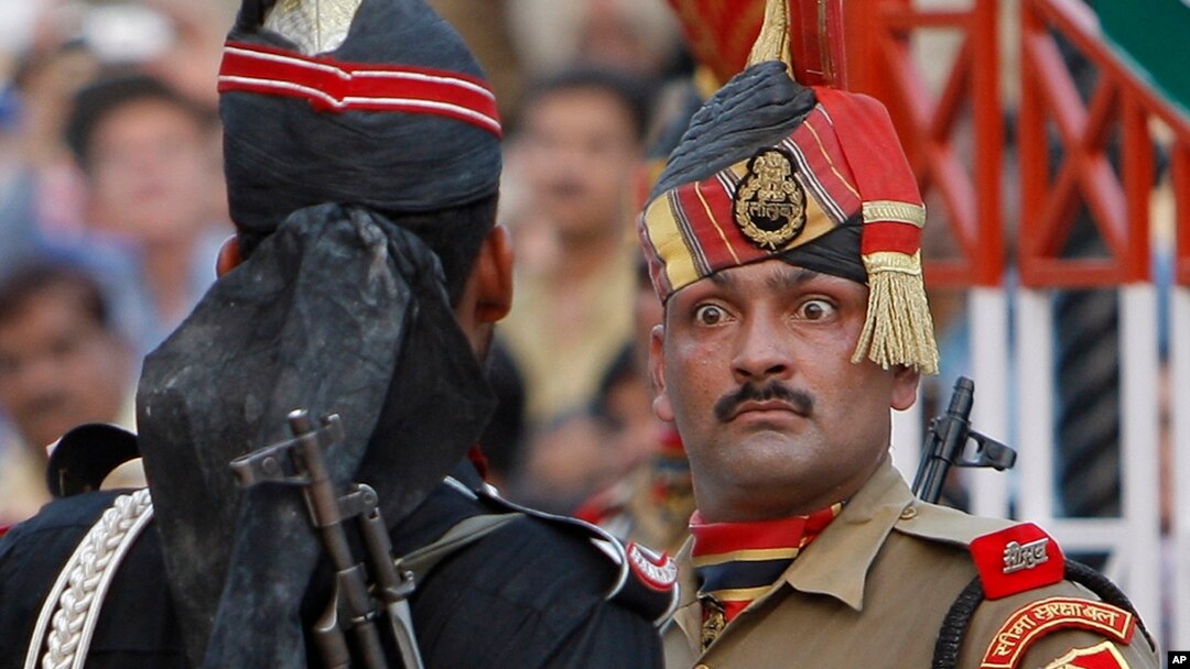 پاکستان اور بھارت کے درمیان واہگہ کی سرحد پر ہونے والی روزانہ کی تقریب کے دوران دونوں ملکوں کے دو سپاہی ایک دوسرے کو آنکھیں دکھا رہے ہیں۔ (فائل فوٹو)