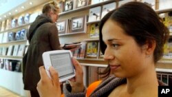 FILE - A woman reads an E-Book at the Book Fair in Frankfurt, central Germany. 