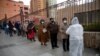 Un trabajador de salud habla con personas en la fila para recibir inyecciones de la vacuna Sinopharm COVID-19 dentro de la universidad pública Universidad Mayor de San Andrés 50 años en La Paz, Bolivia, 17 de mayo de 2021.