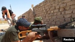 FILE - Members of Iraqi security forces are seen during a fight with Islamic State (IS) militants on the outskirts of Ramadi, Sept. 14, 2014. 