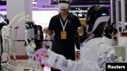 A staff member operates a Wanda robot developed by UniX AI at the World Robot Conference in Beijing, Aug. 21, 2024. 