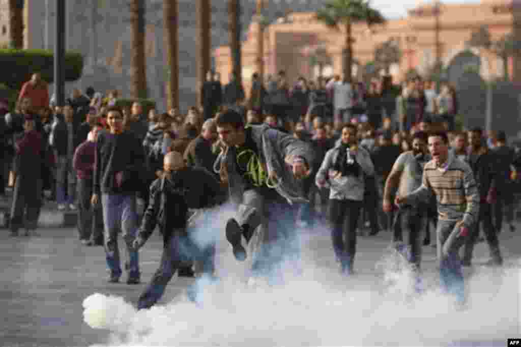 FILE - In this Tuesday, Jan. 25, 2011 file photo, a protester kicks a tear gas canister at a demonstration in Cairo, Egypt. The protests in Egypt are about free elections and overthrowing a longtime dictator? Not according to China's state media, which is