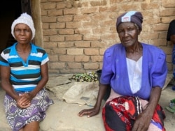 Ninety-four year-old Rudiya Kuhwenya (R) was turned away at the local distribution center in Mudzi district east of Harare in Zimbabwe, Feb. 20, 2020, as her name was not on the list of beneficiaries.