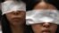 Protesters cover their eyes with white ribbons to symbolize mourning, as a protest to urge the Chinese authorities to carry out a proper investigation into the death of dissident Li Wangyang in Hong Kong June 10, 2012. 