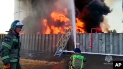 Vatrogasci rade na gašenju požara u rezervoaru nafte u Rostovskoj oblasti u Rusiji, na fotografiji napravljenoj od video snimka koji je objavila pres-služba Ministarstva za vanredne situacije Rusije, 18. juna 2024.
