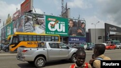 Des écoliers devant un panneau publicitaire avant le referendum, Abidjan, le 27 octobre 2016