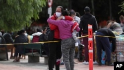 Una mujer migrante venezolana abraza a un familiar mientras se prepara para viajar a la frontera en autobús. Bogotá, 2 de julio de 2020.