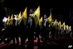 FILE - Hezbollah fighters march at a rally in a Beirut suburb, May 31, 2019. Lebanon's relations with wealthy Gulf states have been strained for years by the growing influence of the Iran-backed Hezbollah movement.