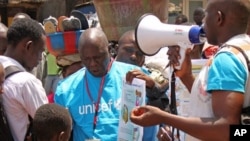 Health workers teach people about the Ebola virus and how to prevent infection, in Conakry, Guinea, March 31, 2014. 