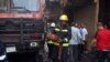 A fireman folds a fire extinguisher tube after his truck runs out of water in a busy, commercial area downtown Cairo on May 11, 2016. (VOA /Hamada Elrasam)