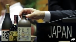 El sake japonés, declarado Patrimonio Cultural Inmaterial, se exhibe en la mesa de la delegación de Japón durante una Convención sobre Patrimonio Mundial de la UNESCO, en Asunción, Paraguay, el miércoles 4 de diciembre de 2024. (Foto AP/Marta Escurra).