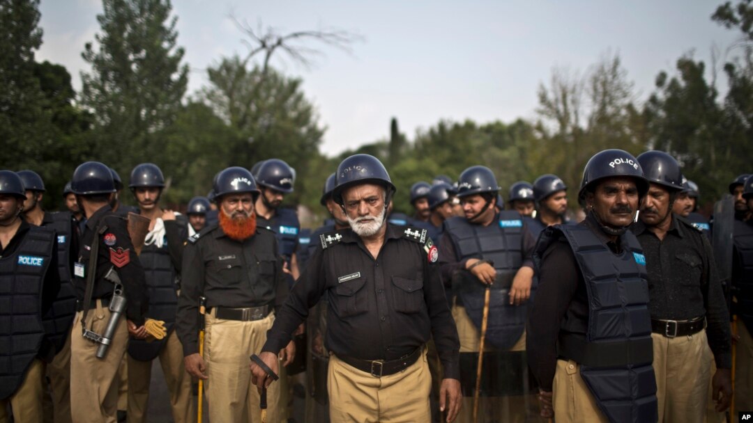 Pakistani police officers stand guard near the Parliament building after tens of thousands of protesters entered Islamabad's high-security Red Zone the night before, five days after arriving in the capital from the eastern city of Lahore in convoys, in Is