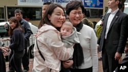 Hong Kong's chief executive elect Carrie Lam (center right) poses with local residents in Hong Kong, March 27, 2017.