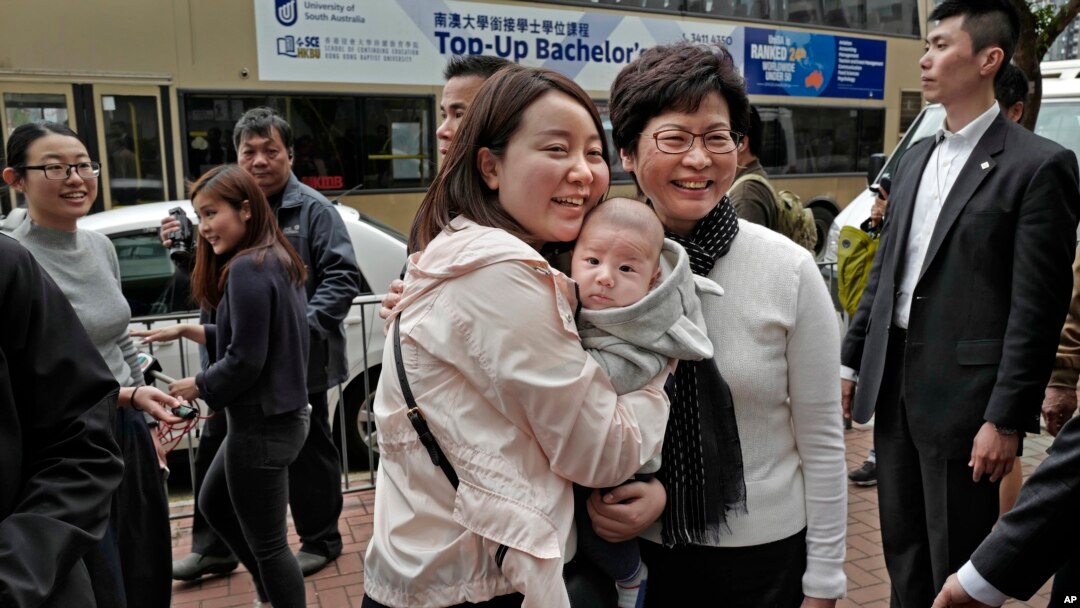 新当选的香港特首林郑月娥(前右一)3月27日在香港与当地居民合影。