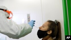 A woman undergoes the rapid antigen test for the coronavirus in Prague, Czech Republic, Dec. 16, 2020.