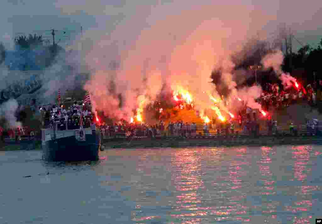 A boat with players cruises on Sava river as Red Star fans celebrate after their team won the Serbian soccer league title in Belgrade, May 22, 2021.