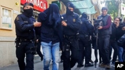 Des policiers de Mossos d'Esquadra, la police de la région de Catalogne, emmènent un homme non identifié, à Barcelone, Espagne, 25 avril 2017.