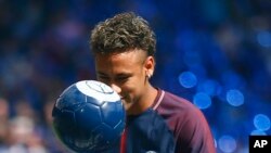 La star brésilienne Neymar fixe le regard à la balle lors de sa présentation officielle aux fans, au stade Parc des Princes à Paris, 5 août 2017. 