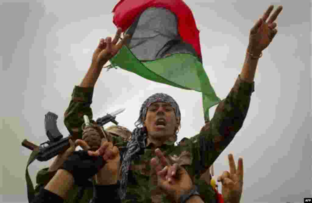 Libyan rebels react on the frontline of the outskirts of the city of Ajdabiya, south of Benghazi, eastern Libya, Monday, March 21, 2011. The international military intervention in Libya is likely to last "a while," a top French official said Monday, echoi