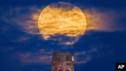 A pink supermoon rises in the night sky over Coit Tower in San Francisco on April 26, 2021.