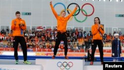 Second-placed Sven Kramer (L) of the Netherlands and his compatriot third-placed Bob de Jong (R) applaud winner Jorrit Bergsma of the Netherlands, during the flower ceremony for the men's 10,000 meters speed skating race at the Adler Arena, in the Sochi 2