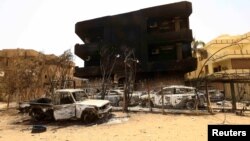 Damaged cars and buildings are seen at the central market in Khartoum North