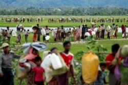FILE - Rohingya refugees, who crossed the border from Myanmar, walk toward refugee camps, in Palang Khali, near Cox's Bazar, Bangladesh, Oct. 19, 2017.
