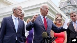 President Joe Biden, with a bipartisan group of senators, speaks Thursday June 24, 2021, outside the White House in Washington. Biden invited members of the group of 21 Republican and Democratic senators to discuss the infrastructure plan. From left…