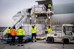 FILE PHOTO: Workers unload a shipment of Chinese company Sinopharm's coronavirus disease (COVID-19) vaccine as it arrives at Budapest Airport, Hungary, Feb. 16, 2021.