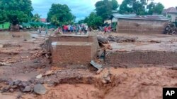 Residents inspect the damage at a village hit by a flash flood in East Flores, Indonesia, April 4, 2021.