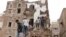 People stand on the debris of a house that recently collapsed due to heavy rains in the old quarter of Sanaa, Yemen May 3, 2020.