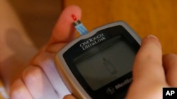 FILE - A diabetic checks his blood sugar level.