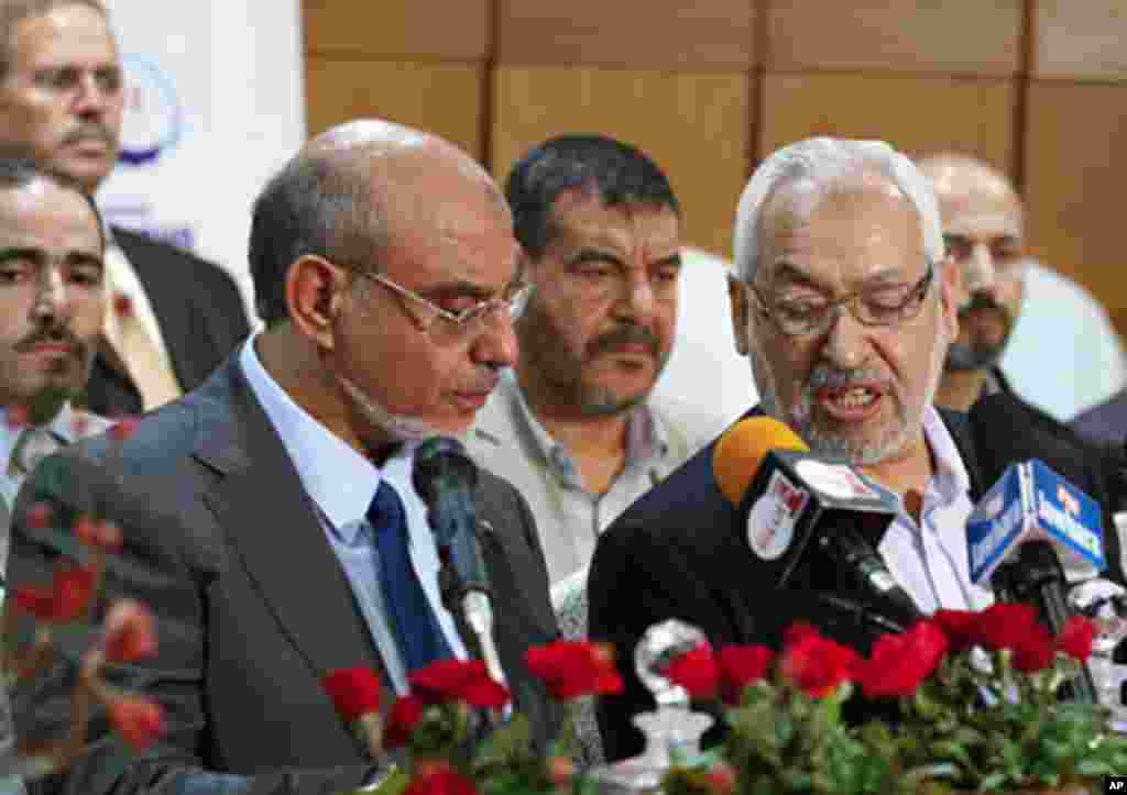 Rachid Ghannouchi (R), leader of the Islamist Ennahda party, speaks with his secretary-general Hamadi Jbeli (L) during a news conference in Tunis, October 28, 2011