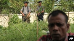 Seorang pria Hindu menghindari kekerasan di Maungdaw, Rakhine sementara dua polisi Myanmar mengawasi di kejauhan (foto: dok). 