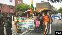 Participants holding banners march through the streets of New York for the African Diaspora Parade, Aug. 23, 2014. (Adam Phillips/VOA)