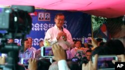 Opposition Cambodia National Rescue Party leader Sam Rainsy speaks at his party headquarters of Chak Angre Leu to celebrate his party's one year anniversary, in Phnom Penh, Cambodia, Monday, April 7, 2014. (AP Photo/Heng Sinith)