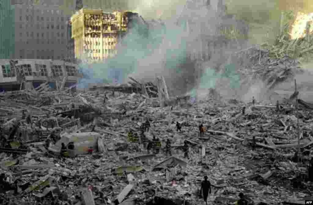 Firefighters walk through smoldering debris at the site of the World Trade Center in New York Tuesday, Sept. 11, 2001. Two planes crashed into the upper floors of both World Trade Center towers minutes apart Tuesday morning, collapsing the 110-story build