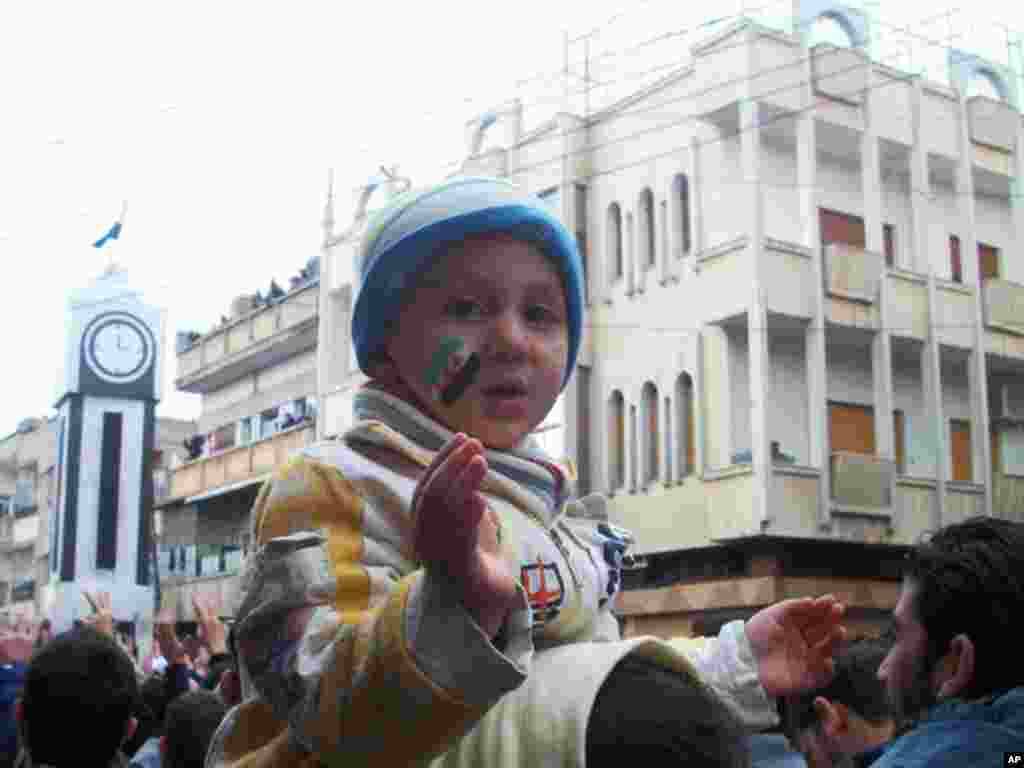 A child is pictured as demonstrators protest Syria's President Bashar al-Assad in Khalidieh, near Homs, January 15, 2012. (Reuters)
