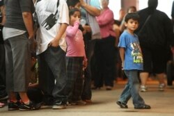 FILE - Children stand in line with some of the thousands of young immigrants at Chicago's Navy Pier on Aug. 15, 2012.