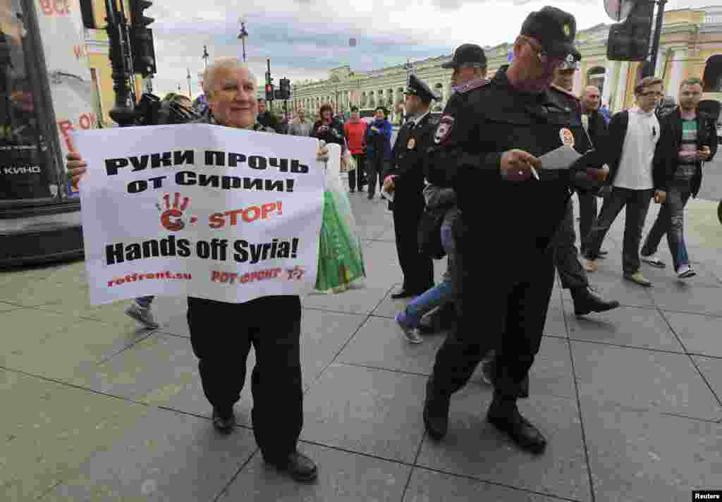 A man protests possible military action in Syria as the first day of the G20 Summit gets underway in St. Petersburg, Sept. 5, 2013.