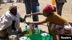 A man receives cooking oil at an emergency food aid distribution center in the village of Estayish in Ethiopia's northern Amhara region, Feb. 11, 2016.