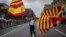 A woman waves flags of Catalonia and Spain as people celebrate a holiday known as "Dia de la Hispanidad" or Spain's National Day in Barcelona, Spain, Oct. 12, 2017. 