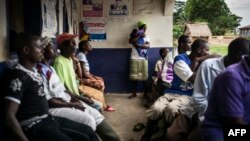 FILE - A mother holds her newborn in the remote health center in the Liberian village of Mendicorma, just across the border with Sierra Leone on April 27, 2016. During the ebola epidemic, many farmers in Guinea, Sierra Leone and Liberia were unable to grow or sell their crops because of measures to contain the virus.