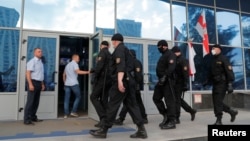 FILE - Belarusian law enforcement officers enter the building of the Belarusian National State TV and Radio Company, in Minsk, Belarus, Aug. 15, 2020. 