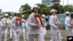 Members of Falun Gong hold portraits of victims during a protest against what they say is the Chinese government's policy of harassment and torture of its members in China, July 22, 2012, in Taipei, Taiwan. 